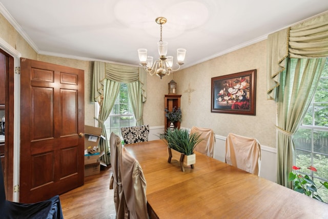 dining space featuring ornamental molding, a healthy amount of sunlight, an inviting chandelier, and light wood-type flooring