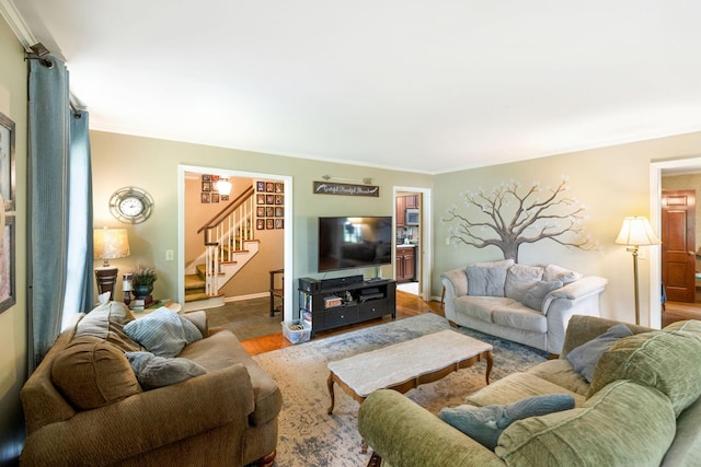 living area with ornamental molding, stairway, baseboards, and wood finished floors