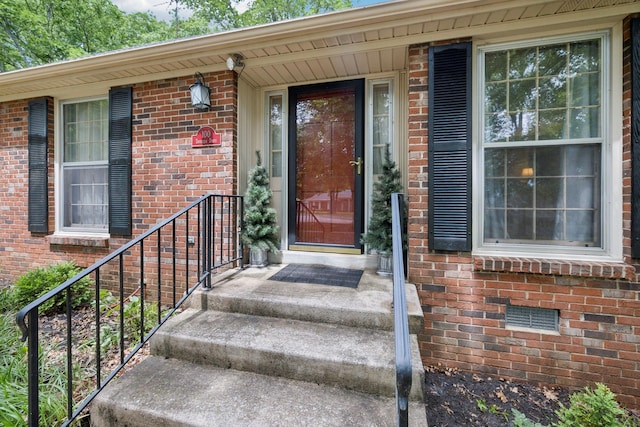 entrance to property featuring brick siding