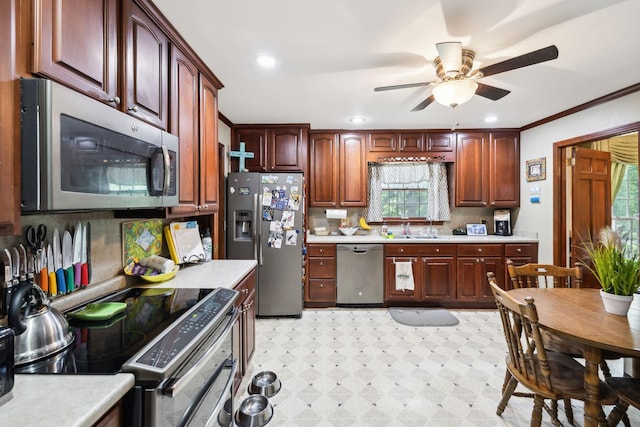 kitchen featuring light floors, stainless steel appliances, ceiling fan, a sink, and light countertops