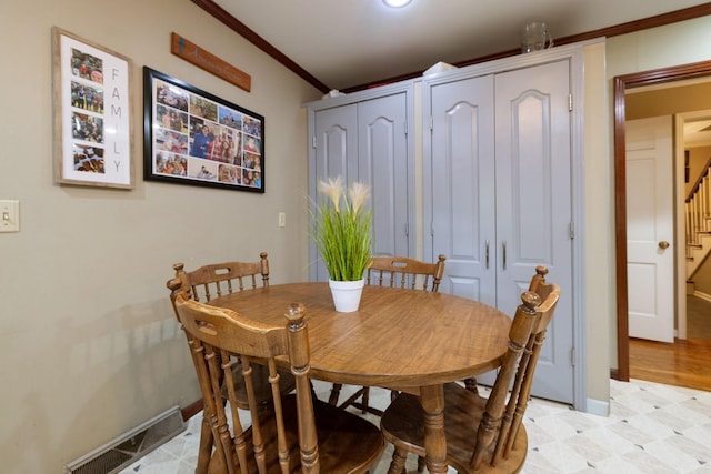 dining space with light floors, visible vents, baseboards, stairway, and ornamental molding