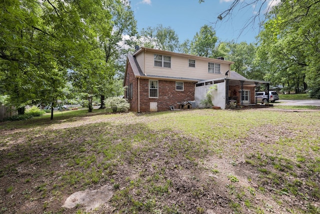 rear view of property with a chimney, brick siding, and a lawn