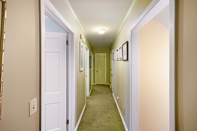 corridor with crown molding, light carpet, and baseboards