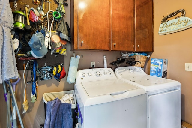 washroom featuring washing machine and dryer and cabinet space