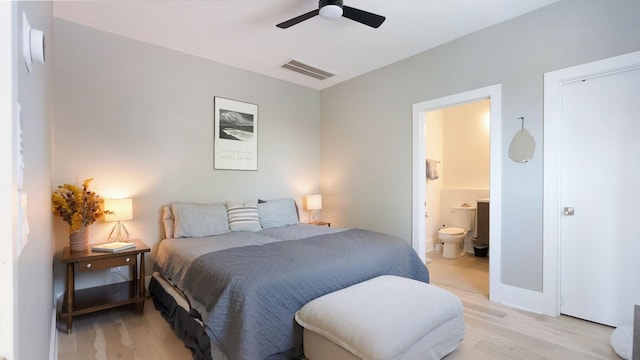bedroom featuring light wood finished floors, connected bathroom, a ceiling fan, visible vents, and baseboards