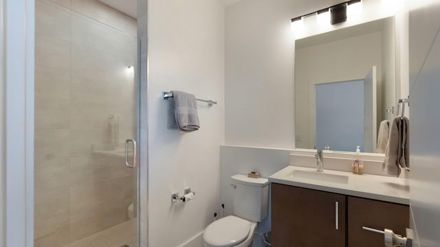 bathroom featuring a stall shower, vanity, and toilet