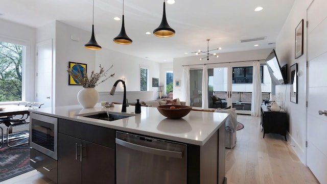 kitchen featuring recessed lighting, dishwasher, a sink, open floor plan, and a center island with sink