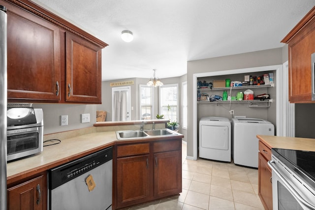 3144 Holly Pt, Clarksville, TN 37043 - kitchen with a sink, independent washer and dryer, light countertops, light tile patterned floors, and appliances with stainless steel finishes