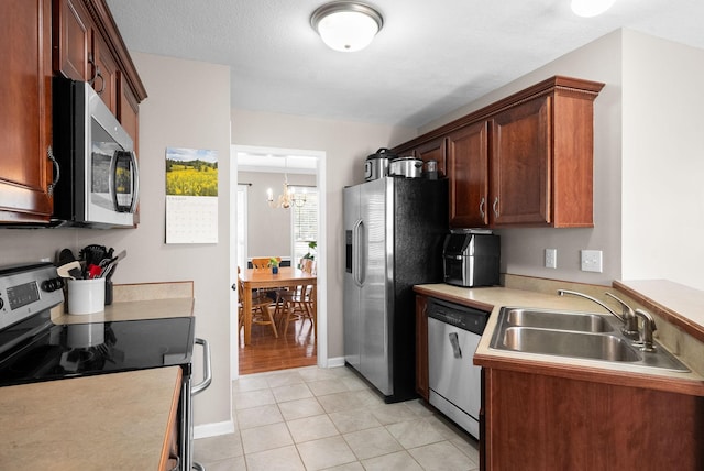 3144 Holly Pt, Clarksville, TN 37043 - kitchen with light tile patterned floors, a sink, a notable chandelier, light countertops, and appliances with stainless steel finishes