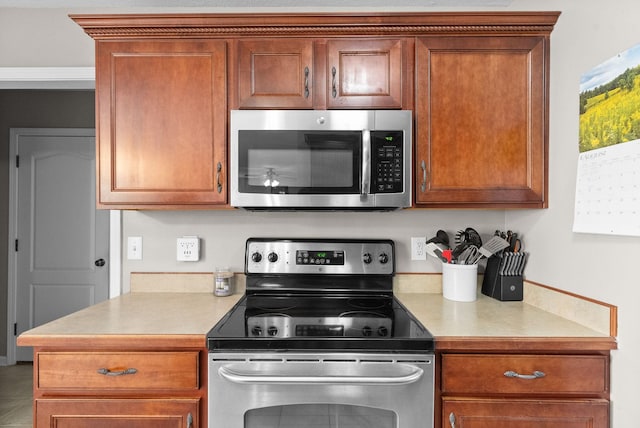 3144 Holly Pt, Clarksville, TN 37043 - kitchen with stainless steel appliances, light countertops, and brown cabinets