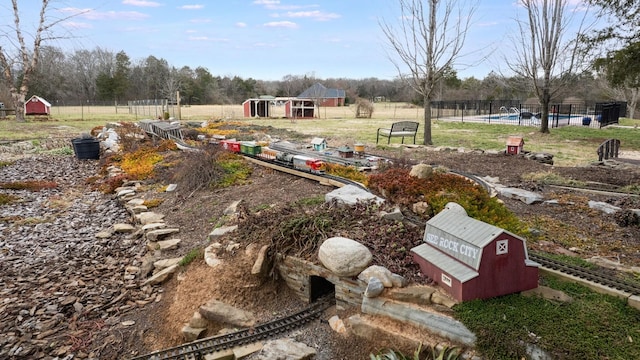 view of yard featuring fence, a storage shed, a fenced in pool, and an outbuilding