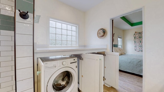 clothes washing area featuring laundry area, light wood-style flooring, and washer / dryer