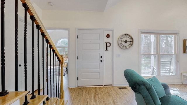 entryway featuring light wood-style floors, a healthy amount of sunlight, and stairway