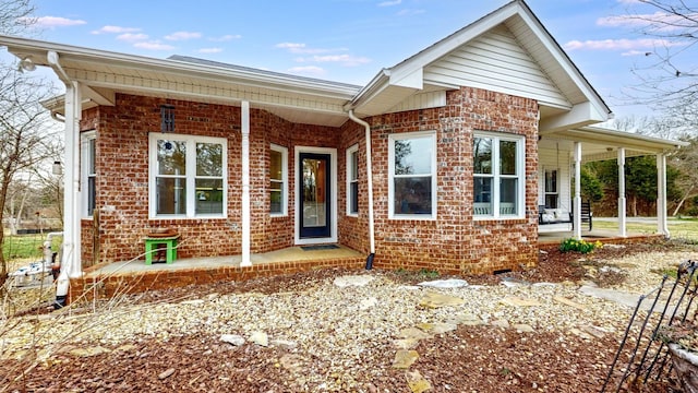 ranch-style house featuring a porch and brick siding