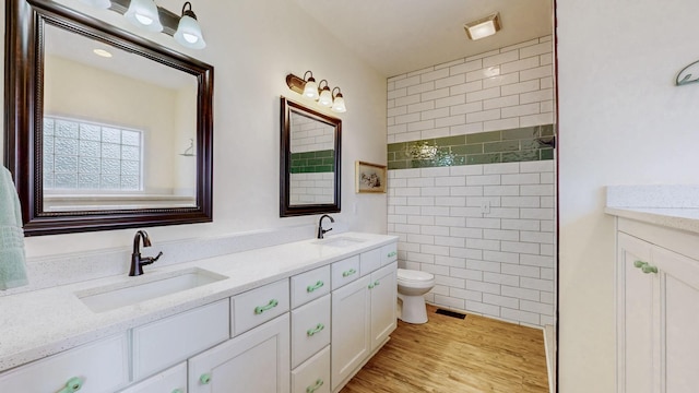 bathroom with double vanity, toilet, visible vents, and a sink