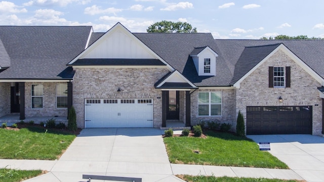 view of front of property featuring concrete driveway, board and batten siding, brick siding, and a front lawn