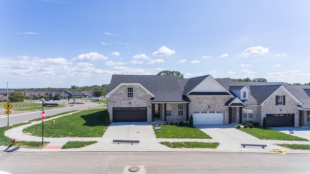 french country style house with concrete driveway, brick siding, a front yard, and stone siding