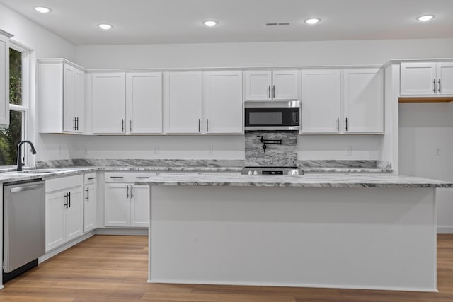 3313 Parker Ln, Chattanooga, TN 37419 - kitchen featuring stainless steel appliances, a sink, white cabinets, light wood finished floors, and recessed lighting