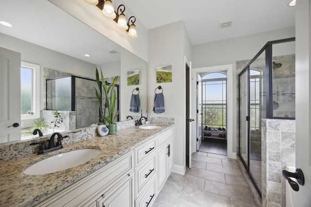 full bath with visible vents, a shower stall, and a sink