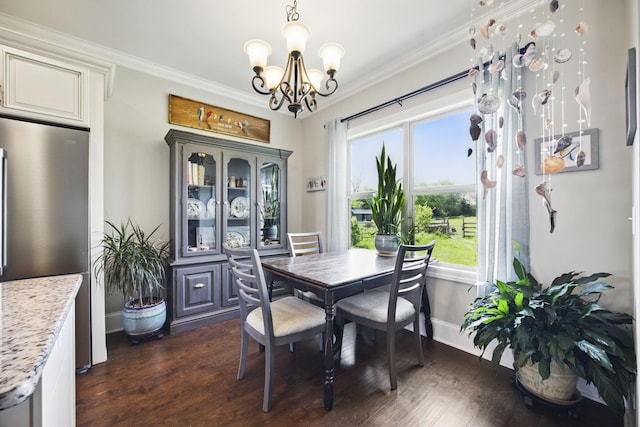 dining space with dark wood finished floors, baseboards, ornamental molding, and a notable chandelier