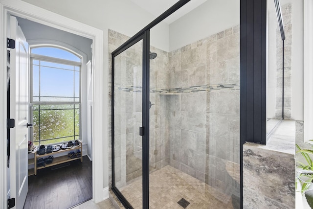 bathroom with a stall shower and wood finished floors