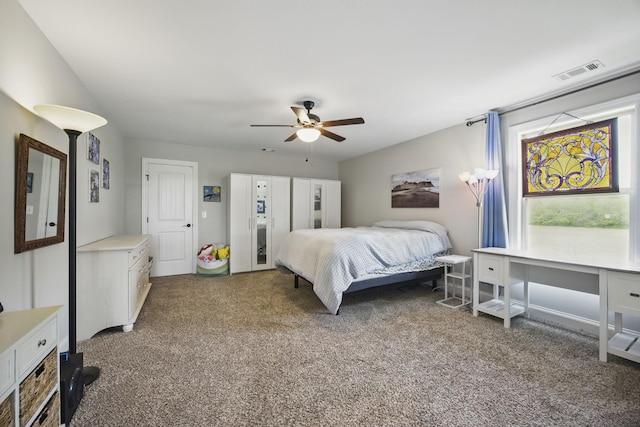 carpeted bedroom featuring ceiling fan and visible vents