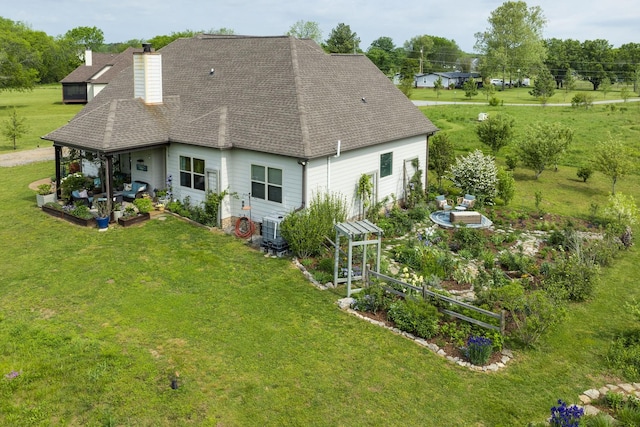 back of house featuring a patio, a chimney, central AC unit, a yard, and roof with shingles