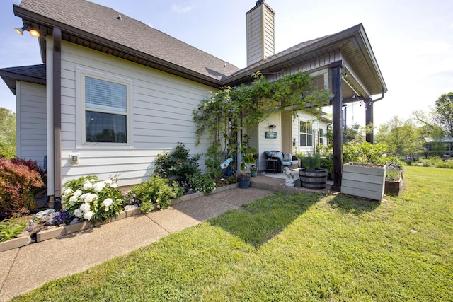 view of front of property featuring a front lawn, roof with shingles, and a chimney