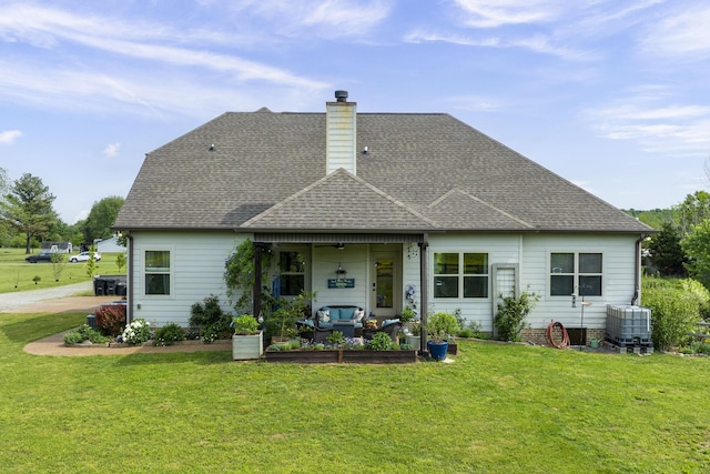 back of house with central air condition unit, a chimney, a lawn, a shingled roof, and outdoor lounge area