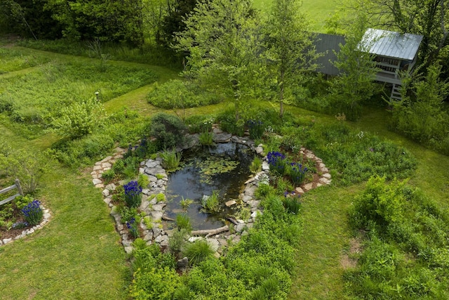 birds eye view of property with a small pond