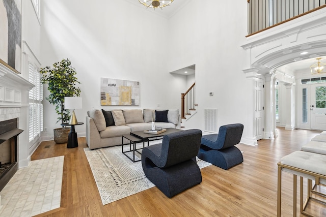 1207 Mullberry Ct, Murfreesboro, TN 37130 - living area featuring stairway, light wood-type flooring, decorative columns, and a towering ceiling