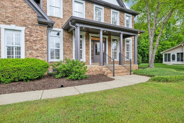 1207 Mullberry Ct, Murfreesboro, TN 37130 - view of exterior entry with a porch, brick siding, and a lawn