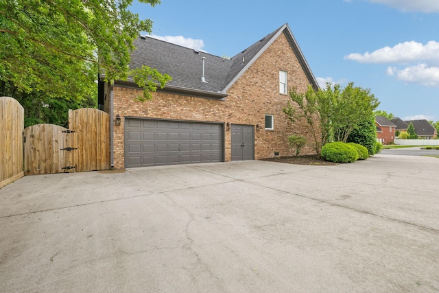 1207 Mullberry Ct, Murfreesboro, TN 37130 - view of property exterior featuring a gate, brick siding, concrete driveway, a garage, and a shingled roof