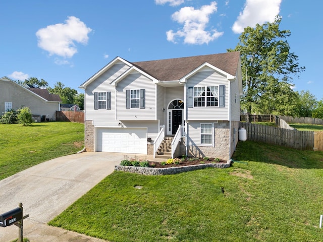bi-level home with driveway, a garage, and stone siding