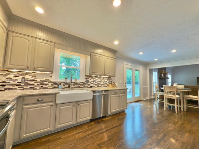 kitchen with crown molding, appliances with stainless steel finishes, decorative backsplash, and dark wood-type flooring