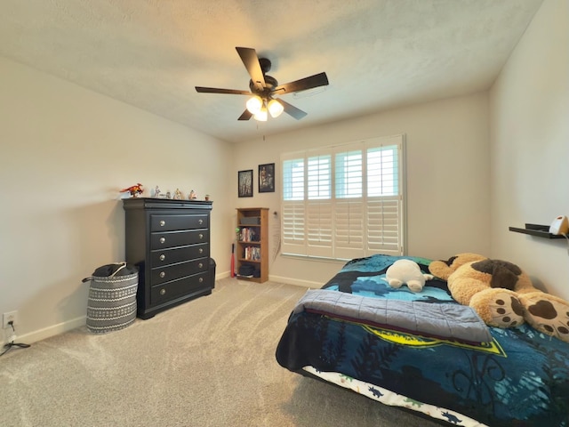 carpeted bedroom with baseboards and a ceiling fan