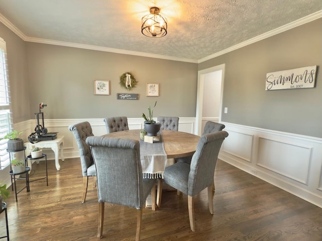 dining space featuring a wainscoted wall, dark wood finished floors, ornamental molding, and a textured ceiling