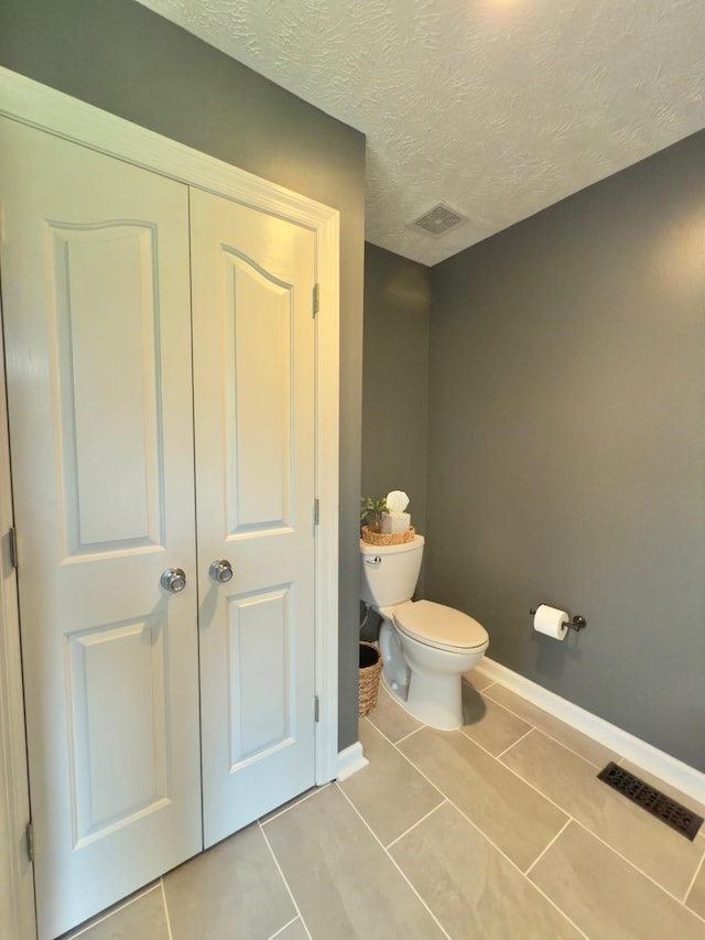 bathroom featuring tile patterned flooring, toilet, and visible vents