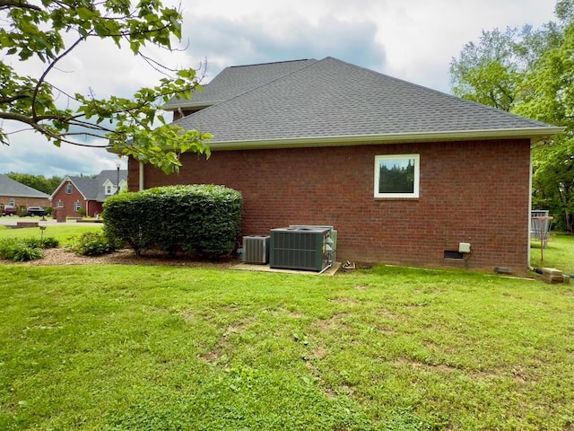 view of side of home with a shingled roof, brick siding, and cooling unit