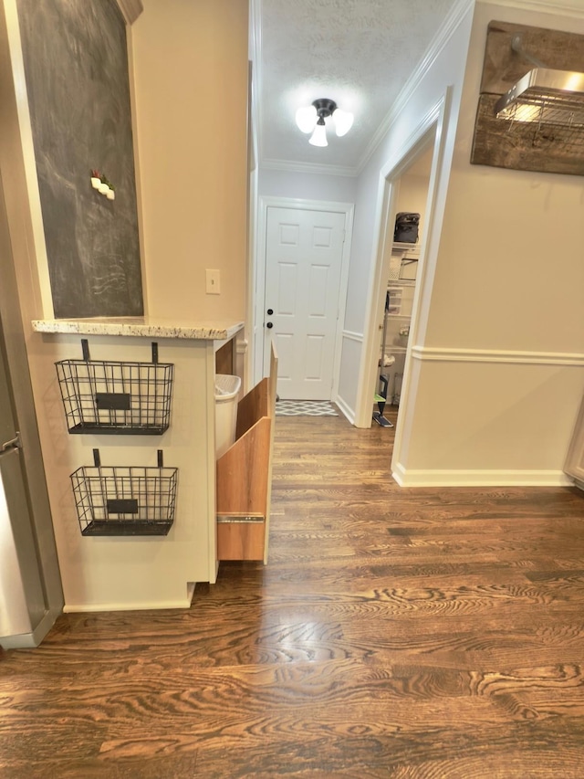 hall with ornamental molding, baseboards, and dark wood-style floors