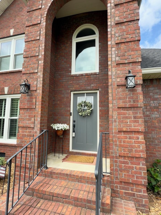 view of exterior entry featuring brick siding