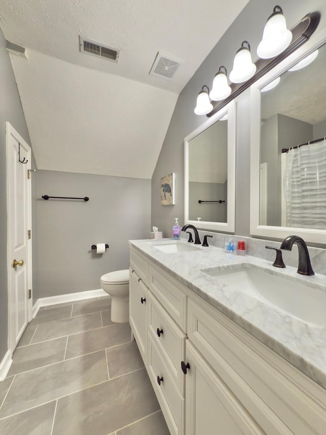 bathroom with a sink, lofted ceiling, and visible vents