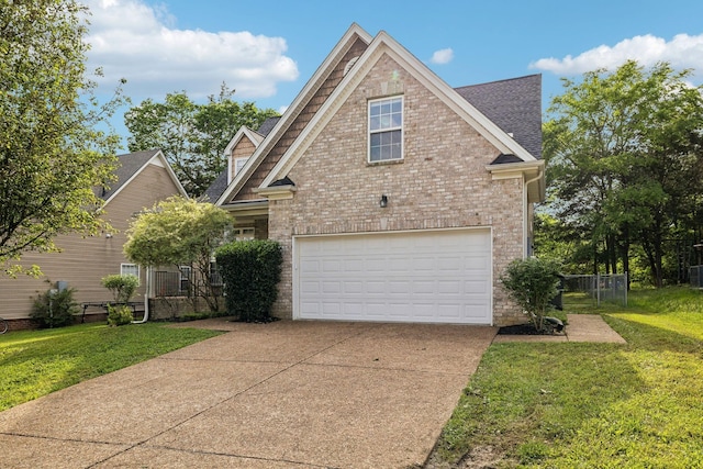 view of front of house with a garage, fence, a front yard, brick siding, and driveway