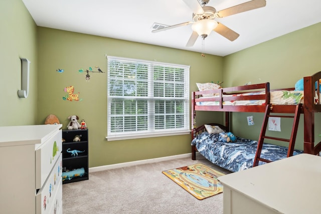 carpeted bedroom featuring baseboards, a ceiling fan, and visible vents
