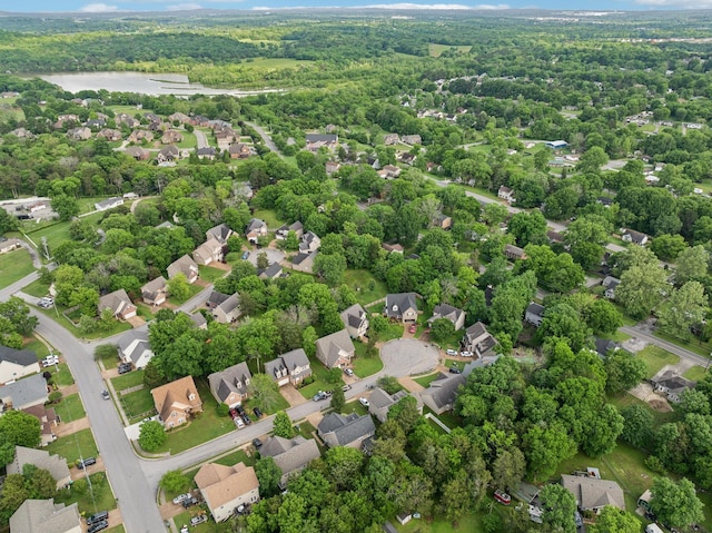 drone / aerial view featuring a water view, a forest view, and a residential view