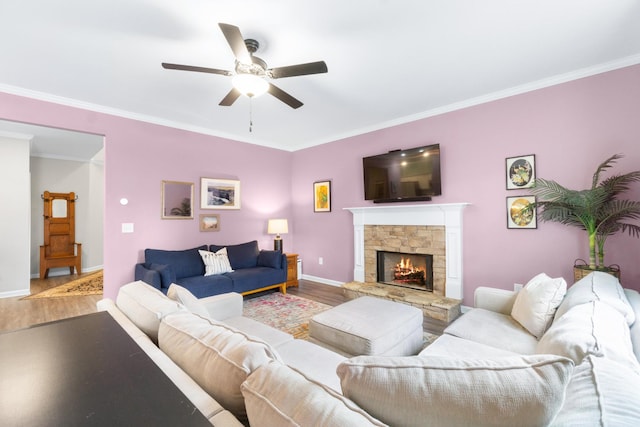 living area with ceiling fan, ornamental molding, baseboards, and wood finished floors