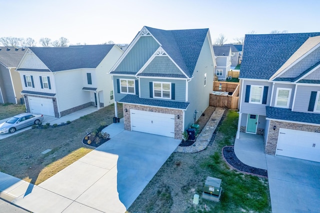 view of front of home with board and batten siding, fence, an attached garage, concrete driveway, and stone siding