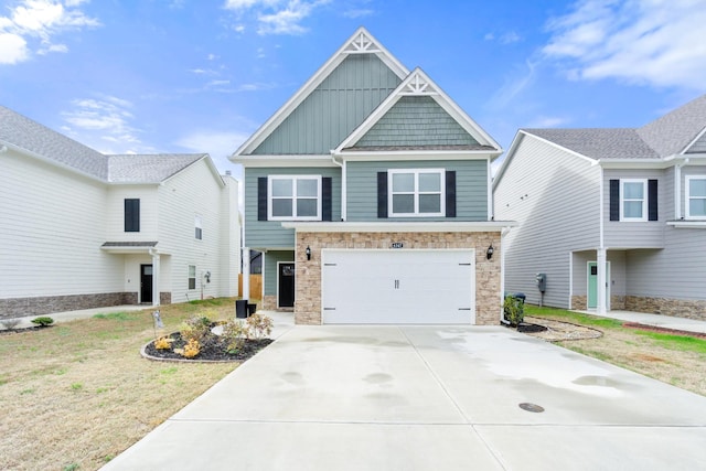 craftsman-style house with board and batten siding, driveway, stone siding, and a garage