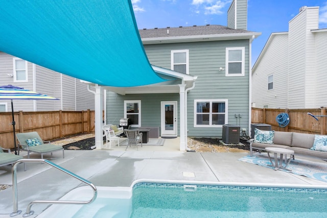 rear view of house featuring central AC unit, a patio area, a fenced backyard, and outdoor lounge area