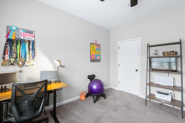 carpeted office space with ceiling fan and baseboards
